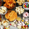 Salty snacks. Pretzels, chips, crackers and candy sweets on table