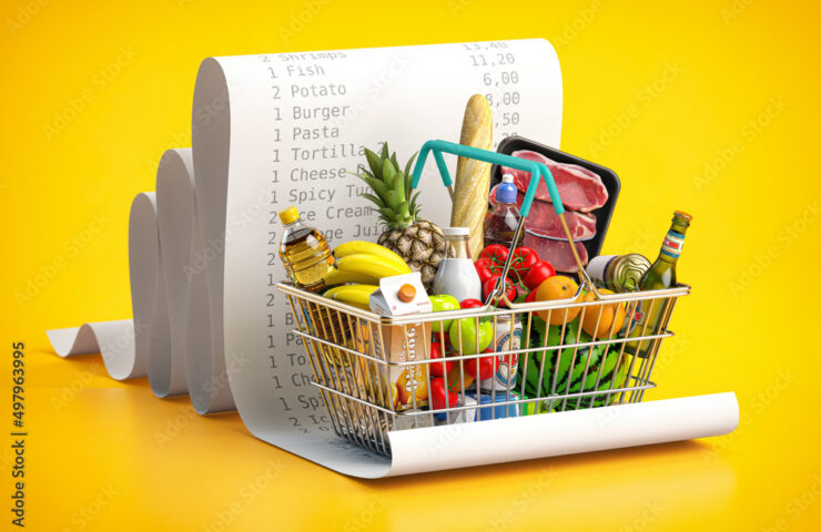 Shopping basket with foods on receipt. Grocery expenses budget, inflation and consumerism concept.
