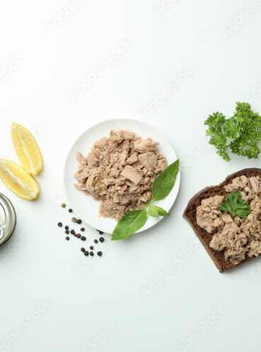 Concept of tasty eating with canned tuna on white background
